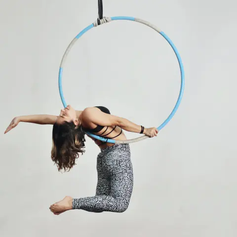 Acróbata en un aro aéreo azul